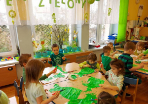 Dzieci malują zieloną farbą sukienki dla pani Wiosny.